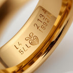 Gold ring with engraved text and heart design inside rings