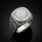 Silver ring with a large moonstone on a black background