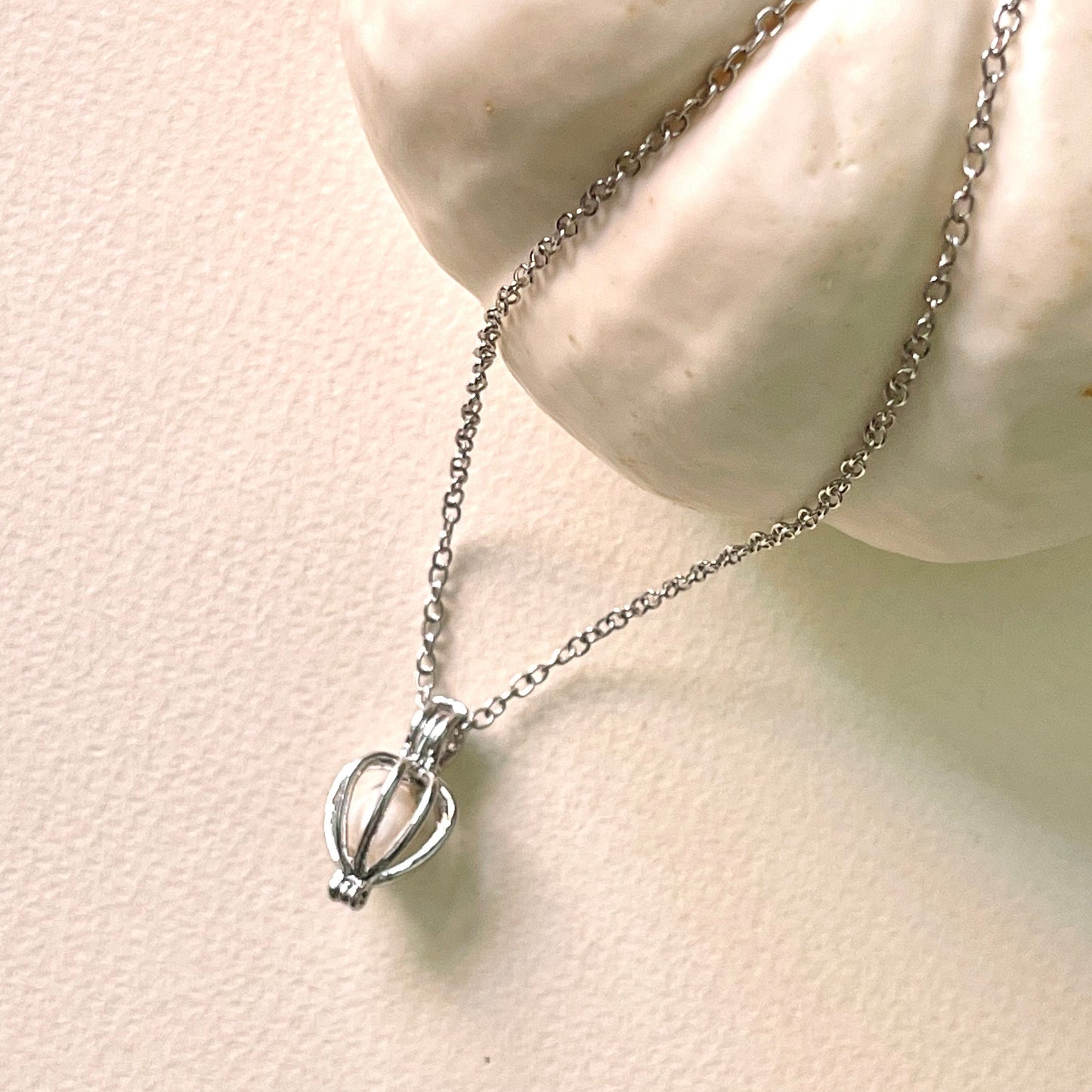 silver cage necklace with white pearl