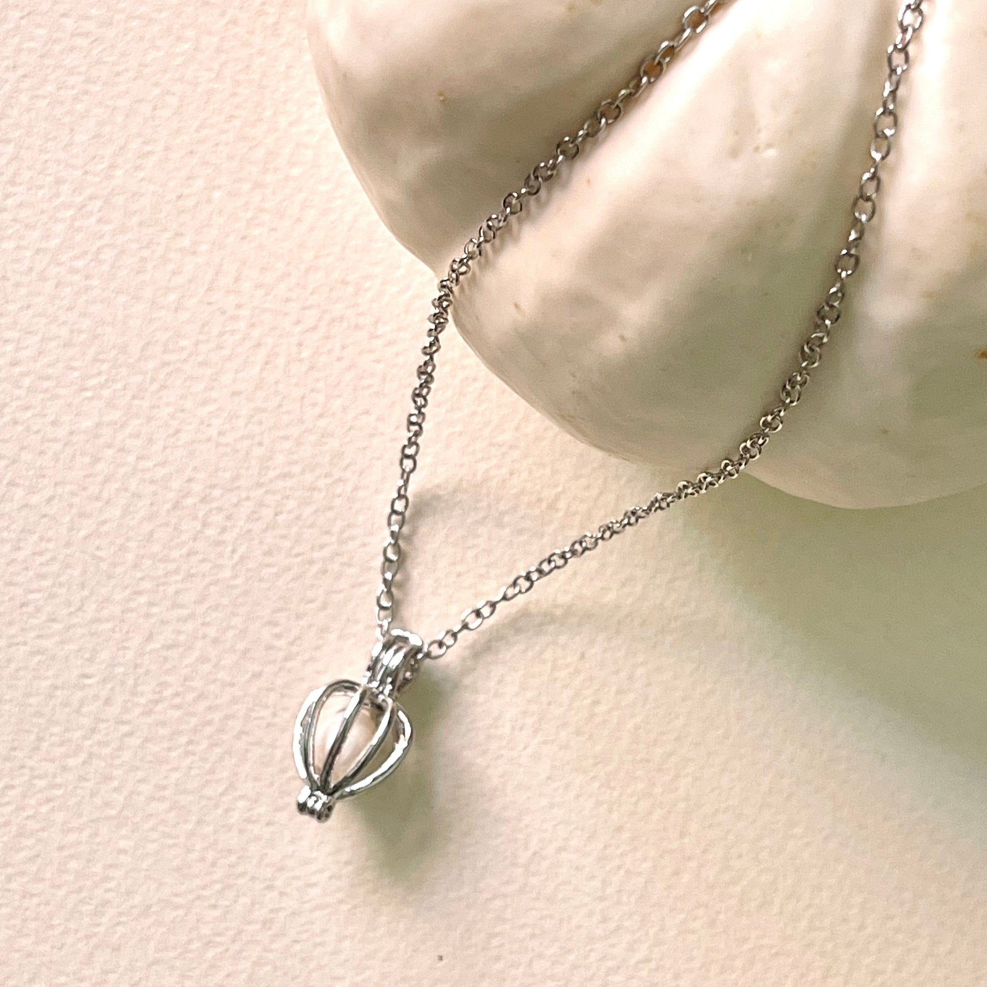 silver cage necklace with white pearl